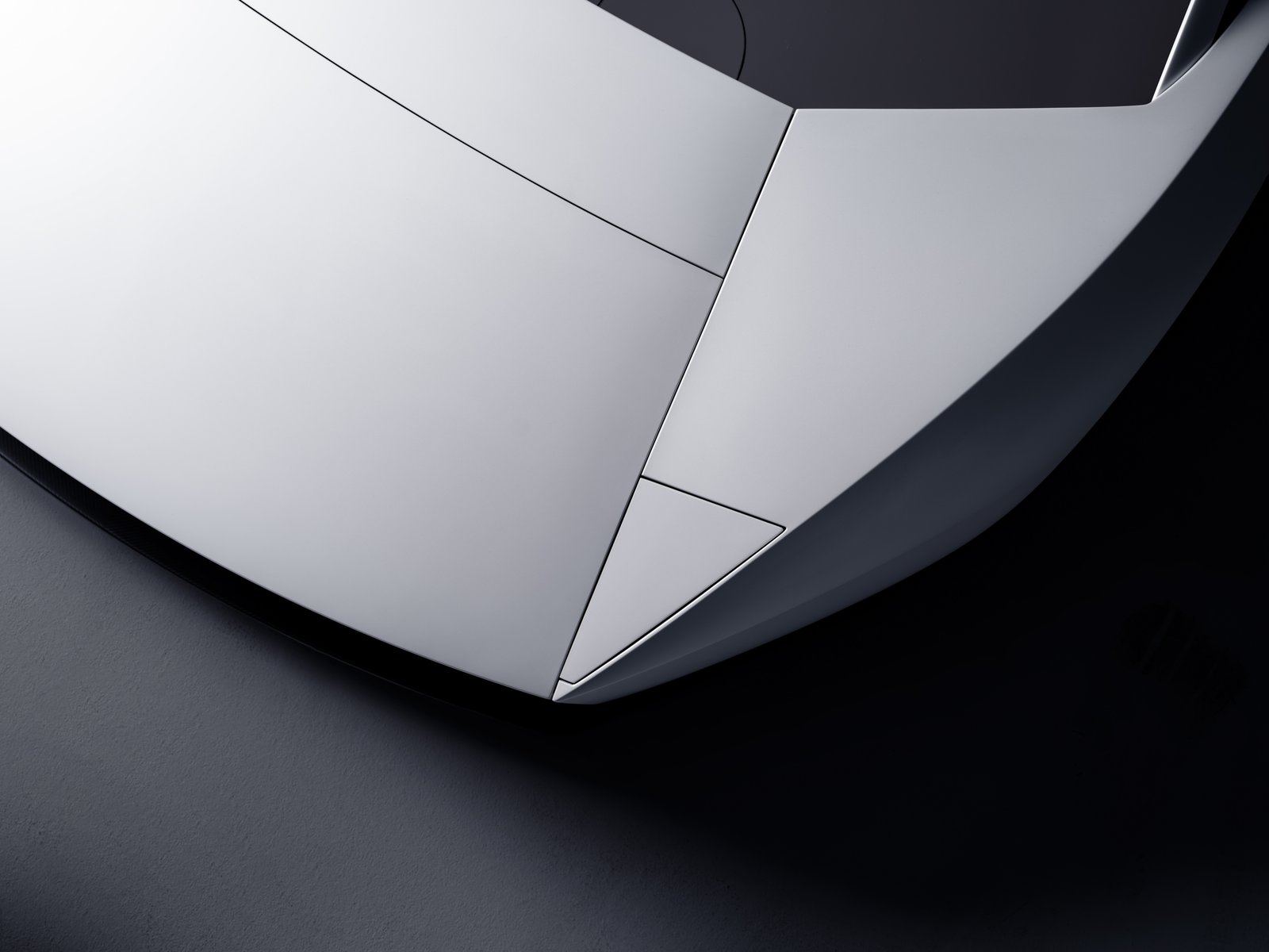 Close-up from above of the Tesla Roadster's white nose, showing flat angular panels with tight shut lines and no visible headlights