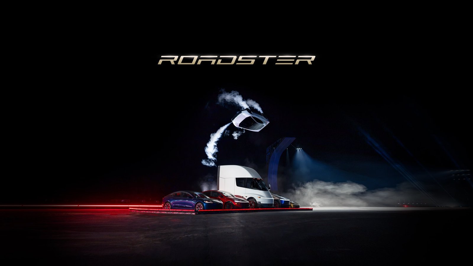 The white Tesla Roadster in mid-air above a Tesla Semi and a row of Tesla cars on a dark stage, white thruster plumes trailing behind it, under a gold ROADSTER wordmark